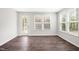 Sunny living room with hardwood floors, a screened door, and windows with white blinds at 1812 Gazania Dr, Fuquay Varina, NC 27526