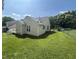 Backyard with green lawn with trees and a chainlink fence offering privacy and outdoor enjoyment at 1819 Collier Rd, Durham, NC 27707