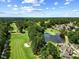 Stunning aerial view of community with mature trees, a pond, and golf course at 20 Nicklaus Way, Clayton, NC 27520