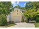 Lovely exterior of home featuring yellow siding, an attached garage, and mature landscaping at 20 Nicklaus Way, Clayton, NC 27520