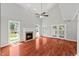 Bright living room boasts hardwood floors, fireplace, and vaulted ceiling with ceiling fan at 20 Nicklaus Way, Clayton, NC 27520