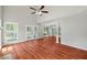 Living room showing hardwood floors, ceiling fan, bright windows, and french doors at 20 Nicklaus Way, Clayton, NC 27520