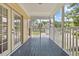 Screened porch with wood flooring, white railing, and view of neighboring homes at 20 Nicklaus Way, Clayton, NC 27520