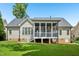 Backyard featuring house elevation, screened porch, well-manicured lawn, and fence at 204 Plantation Dr, Youngsville, NC 27596