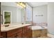 Bathroom features double sink vanity with separate tub and privacy glass window at 204 Plantation Dr, Youngsville, NC 27596