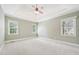 Spacious bedroom with tray ceiling, ceiling fan and multiple windows providing natural light at 204 Plantation Dr, Youngsville, NC 27596