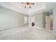 Neutral bedroom with tray ceiling, ceiling fan and doorway access to bathroom at 204 Plantation Dr, Youngsville, NC 27596