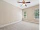 Neutral-toned bedroom features a ceiling fan and two windows that provide natural light at 204 Plantation Dr, Youngsville, NC 27596