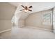 A spacious room with neutral walls, a ceiling fan, carpeted floors, and bright windows offers a cozy retreat at 204 Plantation Dr, Youngsville, NC 27596
