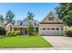 Charming home featuring stone accents, a well-manicured lawn, and a two-car garage at 204 Plantation Dr, Youngsville, NC 27596