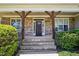 Inviting front porch with stone columns and steps leading to a wood front door at 204 Plantation Dr, Youngsville, NC 27596