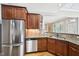 Spacious kitchen featuring stainless steel refrigerator and adjacent dining area with vaulted ceiling at 204 Plantation Dr, Youngsville, NC 27596