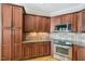 Well-lit kitchen with stainless steel appliances, tile backsplash, and wood cabinetry at 204 Plantation Dr, Youngsville, NC 27596