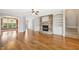 Spacious living room with a stone fireplace, hardwood floors, and built-in bookshelves at 204 Plantation Dr, Youngsville, NC 27596
