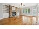 Cozy living room featuring a stone fireplace, built-in bookshelves, and hardwood floors at 204 Plantation Dr, Youngsville, NC 27596