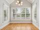 Bright sitting room featuring multiple large windows, hardwood floors and vaulted ceilings at 204 Plantation Dr, Youngsville, NC 27596