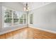 Sunlit sitting room with large windows, hardwood floors and an elegant hanging light fixture at 204 Plantation Dr, Youngsville, NC 27596