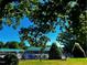 Community pool surrounded by mature trees and a green roof cabana at 2069 White Pond Ct, Apex, NC 27523