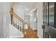 Bright foyer featuring hardwood floors, staircase with wooden railing, and views into the living spaces at 2069 White Pond Ct, Apex, NC 27523