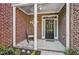 Inviting brick porch with white columns and a rocking chair, offering a cozy entrance to the home at 2069 White Pond Ct, Apex, NC 27523