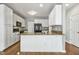 Updated kitchen with white cabinets, granite countertops, an island with sink, and hardwood flooring at 2069 White Pond Ct, Apex, NC 27523