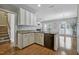Modern kitchen with granite countertops, white cabinets, and stainless steel appliances, open to the living area at 2069 White Pond Ct, Apex, NC 27523