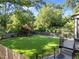 Large, green back yard with a wood fence, patio area, and mature trees perfect for outdoor activities at 2114 Cowper Dr, Raleigh, NC 27608
