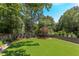 Expansive backyard featuring lush green grass, mature trees, and privacy fence at 2114 Cowper Dr, Raleigh, NC 27608
