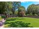 Expansive backyard featuring lush green grass, mature trees, and privacy fence at 2114 Cowper Dr, Raleigh, NC 27608