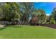 Expansive backyard featuring lush green grass, mature trees, and privacy fence at 2114 Cowper Dr, Raleigh, NC 27608