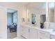 Bright bathroom with double vanity, decorative mirror, and a view into the sitting room at 2114 Cowper Dr, Raleigh, NC 27608