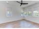 Bright bedroom with a ceiling fan, multiple windows, and light hardwood flooring at 2114 Cowper Dr, Raleigh, NC 27608