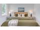 Bright bedroom with a queen bed, throw blanket, white walls, lamps and a patterned rug at 2114 Cowper Dr, Raleigh, NC 27608