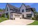 Beautiful exterior view of a two-story home with white painted brick, black roof, manicured landscaping and a driveway at 2114 Cowper Dr, Raleigh, NC 27608