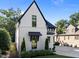Charming home featuring white brick, contrasting black trim, modern windows, and manicured landscaping at 2114 Cowper Dr, Raleigh, NC 27608