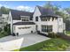 Stunning home featuring a bright white exterior, black trim, attached garage, and well-kept landscaping at 2114 Cowper Dr, Raleigh, NC 27608