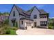 Striking white painted brick two-story home with black trim, black roof, manicured landscaping and a driveway at 2114 Cowper Dr, Raleigh, NC 27608