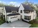 Stunning home featuring a bright white exterior, black trim, attached garage, and well-kept landscaping at 2114 Cowper Dr, Raleigh, NC 27608