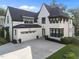 Stunning home featuring a bright white exterior, black trim, attached garage, and well-kept landscaping at 2114 Cowper Dr, Raleigh, NC 27608
