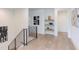 Bright hallway with decorative shelving, iron railings, and light hardwood flooring at 2114 Cowper Dr, Raleigh, NC 27608