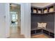 Mudroom with gray custom shelving and seating, offering storage for shoes and decor baskets, and a view to the dining room at 2114 Cowper Dr, Raleigh, NC 27608