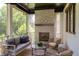 Inviting outdoor living space features a stone fireplace, comfortable seating, and wooded views at 2114 Cowper Dr, Raleigh, NC 27608