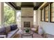 Inviting outdoor living space features a stone fireplace, comfortable seating, and wooded views at 2114 Cowper Dr, Raleigh, NC 27608