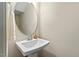 Bathroom featuring a pedestal sink, round mirror, and towel rack at 217 Macy Grove Dr, Chapel Hill, NC 27517