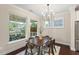Sunlit dining area with a modern chandelier and a view of the covered porch and lush backyard at 217 Macy Grove Dr, Chapel Hill, NC 27517