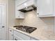 A kitchen showcases a stainless steel stove with a tiled backsplash and white cabinetry at 217 Macy Grove Dr, Chapel Hill, NC 27517