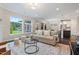 Bright living room with large windows, a comfortable sofa, and a view to the outdoor space and updated kitchen at 217 Macy Grove Dr, Chapel Hill, NC 27517