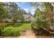 Scenic backyard featuring a lush lawn, flowering shrubs, and mature trees at 2261 Plum Frost Dr, Raleigh, NC 27603