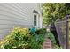 Serene side yard with lush landscaping and a gravel path leading to a black fence at 2617 Cottage Cir, Raleigh, NC 27613