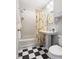 Bathroom featuring subway tiled walls, black and white tiled floors and citrus themed shower curtain at 2804 Barmettler St, Raleigh, NC 27607